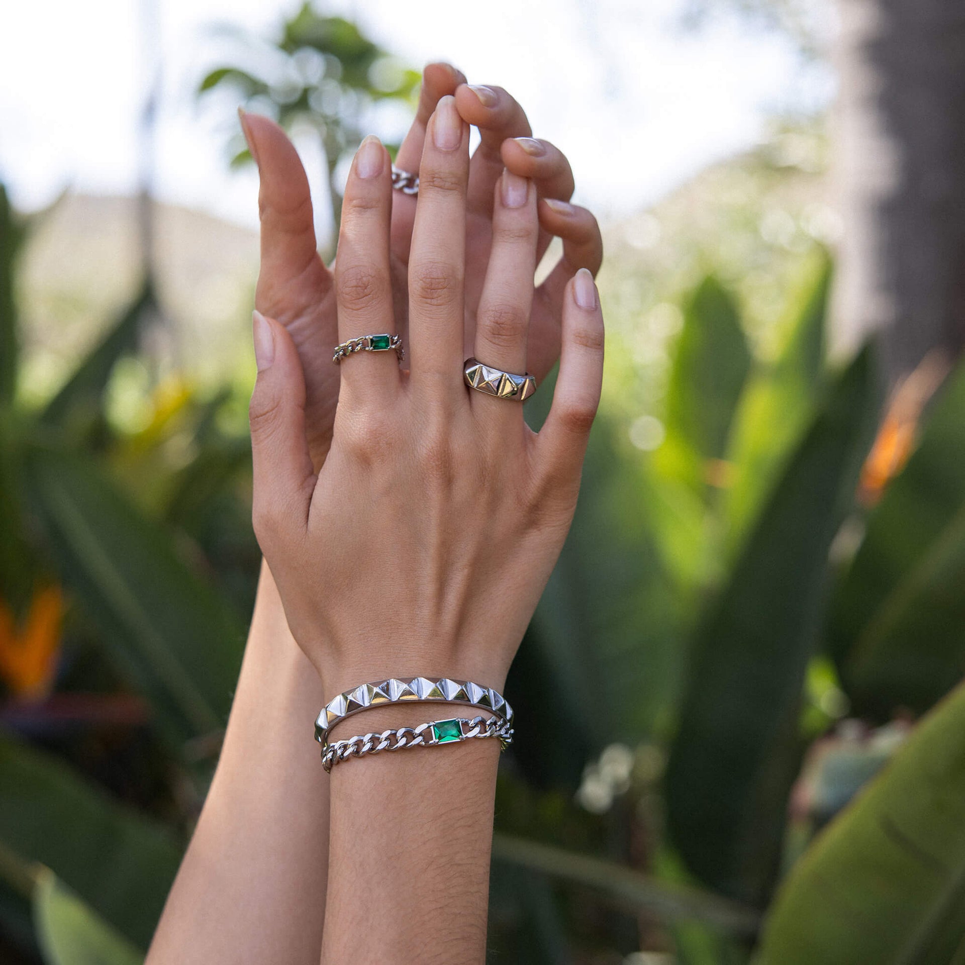 Be You Ring von PURELEI, goldener Edelstahl mit Nieten, elegant getragen vor grünem Naturhintergrund.