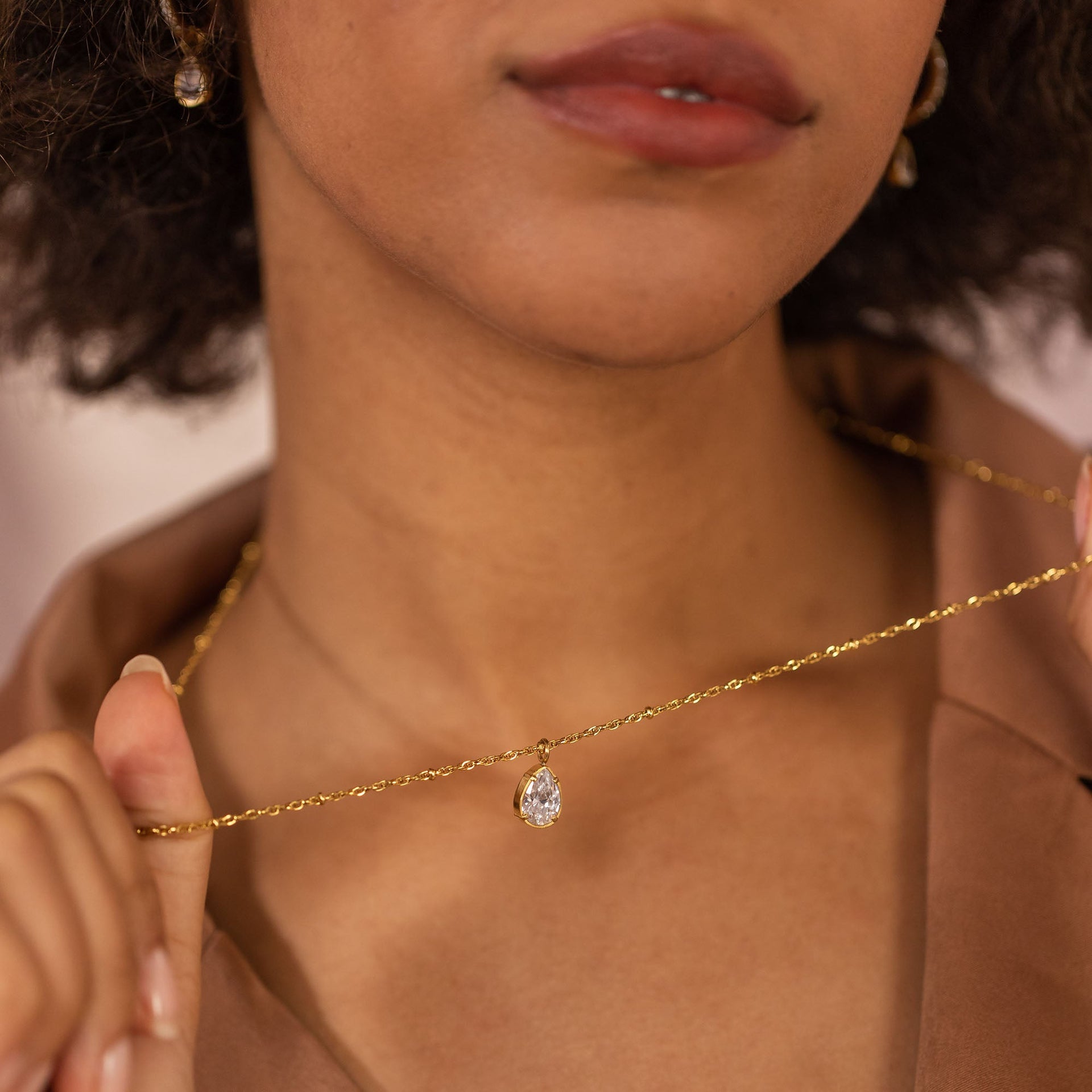 Goldene Kette mit tropfenförmigem Anhänger, getragen von einer Frau, PURELEI.