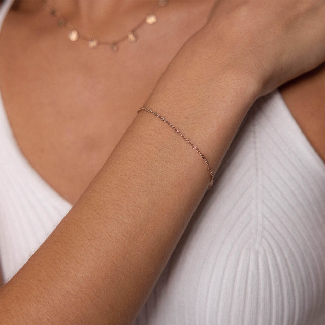 PURELEI Kaula Armband in Roségold, feines, gedrehtes Design, am Handgelenk getragen, schlicht und elegant.