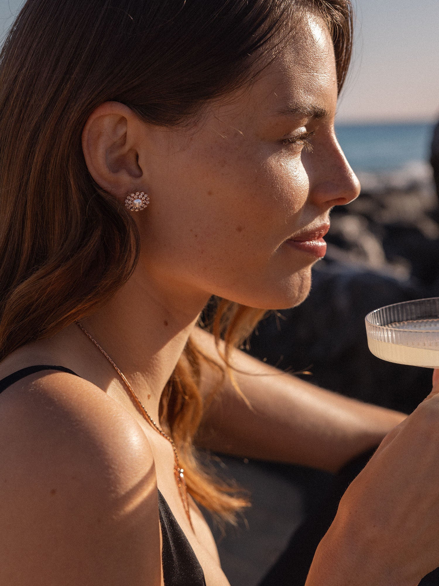 Roségoldene Ohrringe mit funkelnden Details, getragen von einer Frau, PURELEI.