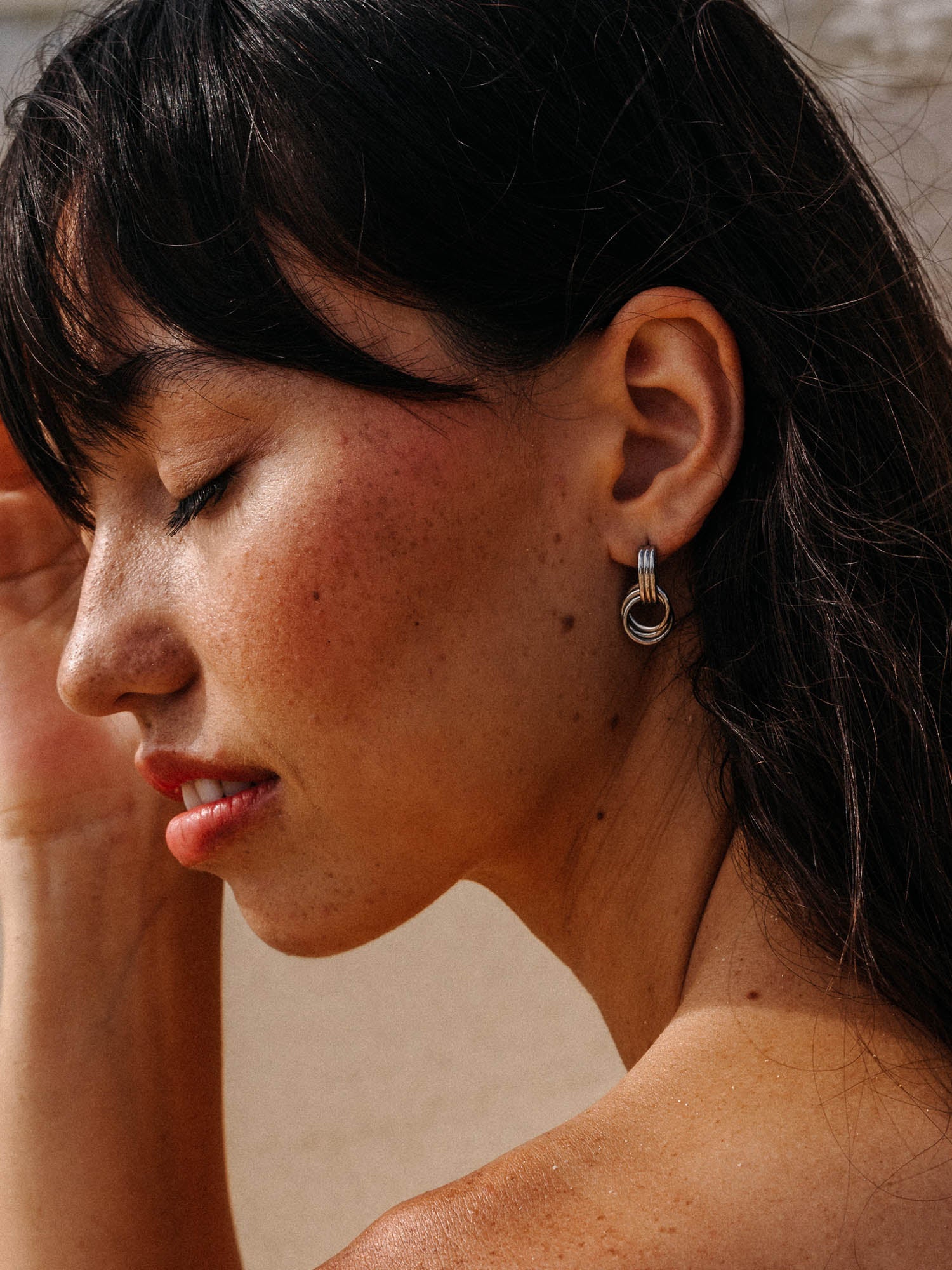 PURELEI He Nui Ohrringe in Silber mit ineinander verschlungenen Ringen, elegant und feminin getragen.