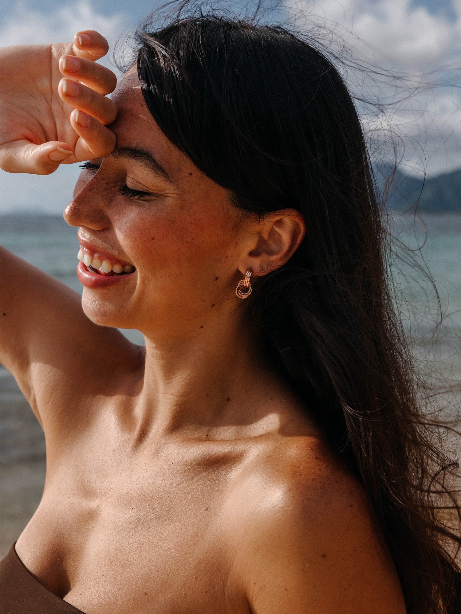 PURELEI He Nui Ohrringe in Roségold, verschlungene Ringe, warmes Sonnenlicht am Strand, elegant und feminin