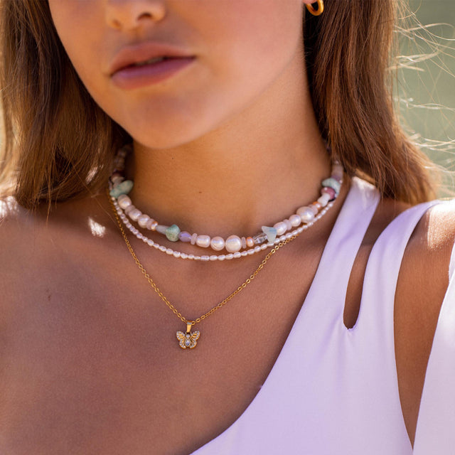 Dreifache Perlenkette mit goldener Schmetterlingsanhänger von PURELEI, elegant und feminin.