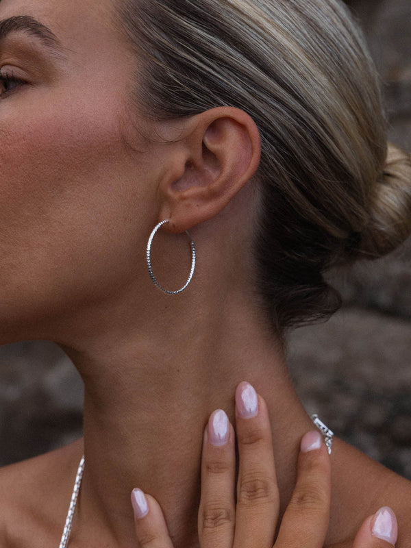 Gleam Ohrringe aus recyceltem Silber mit facettierter Oberfläche, elegant getragen, pure PURELEI Ästhetik.