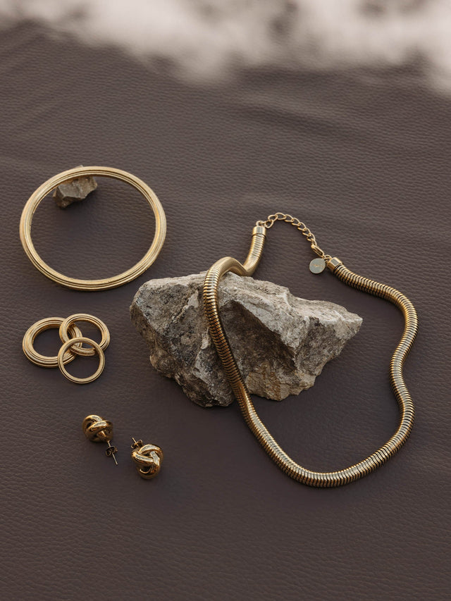 Silberne Schmuckstücke von PURELEI auf braunem Hintergrund, elegant und modern.