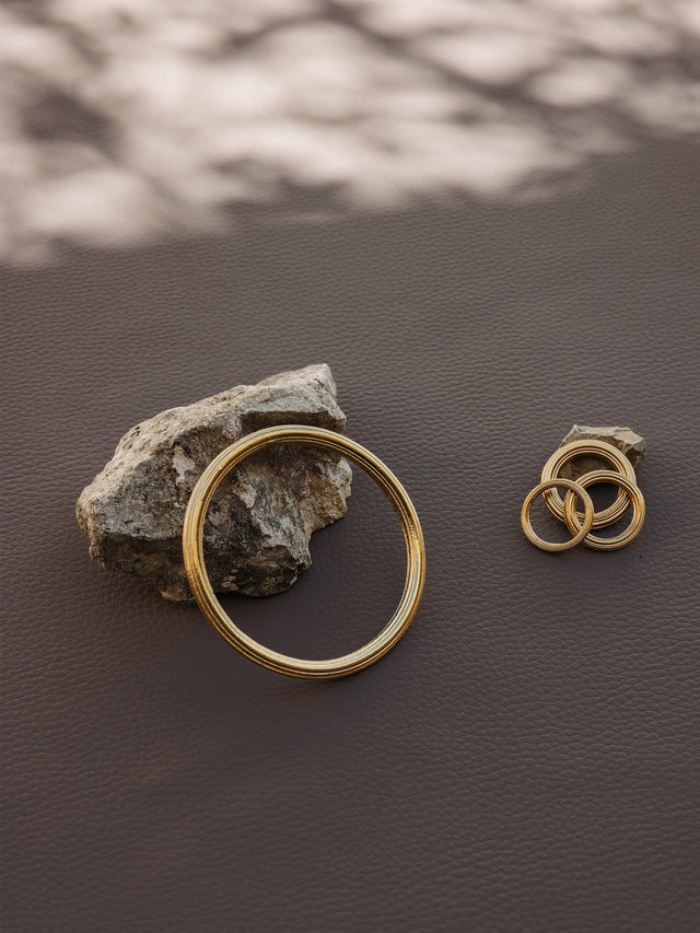 Silberne Ringe von PURELEI auf dunklem Stein, elegant und modern in natürlicher Umgebung.