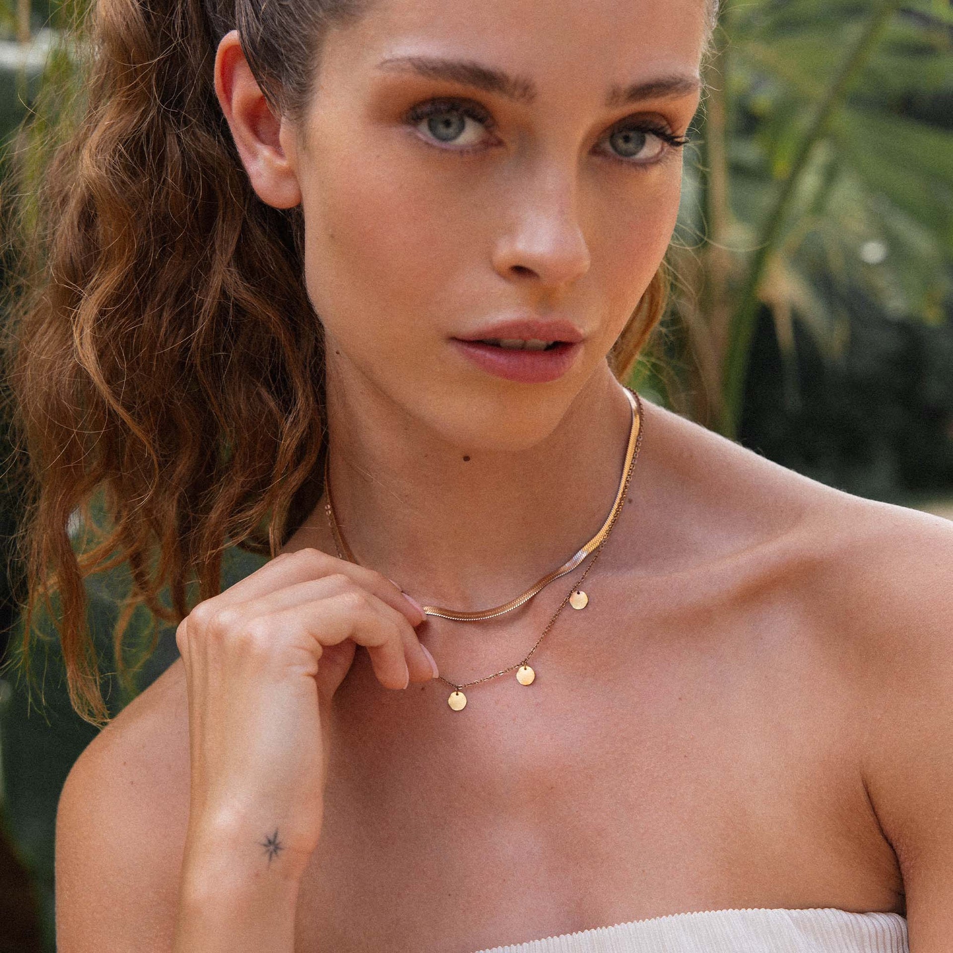 Zarte roségoldene Kette mit Anhängern, getragen in tropischer Umgebung – PURELEI.