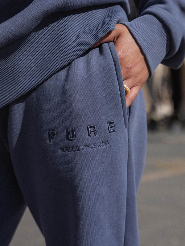 Feeling Pure Sweatpants Dark Blue aus Baumwolle mit geradem Bein und gesticktem PURELEI-Logo in urbaner Atmosphäre