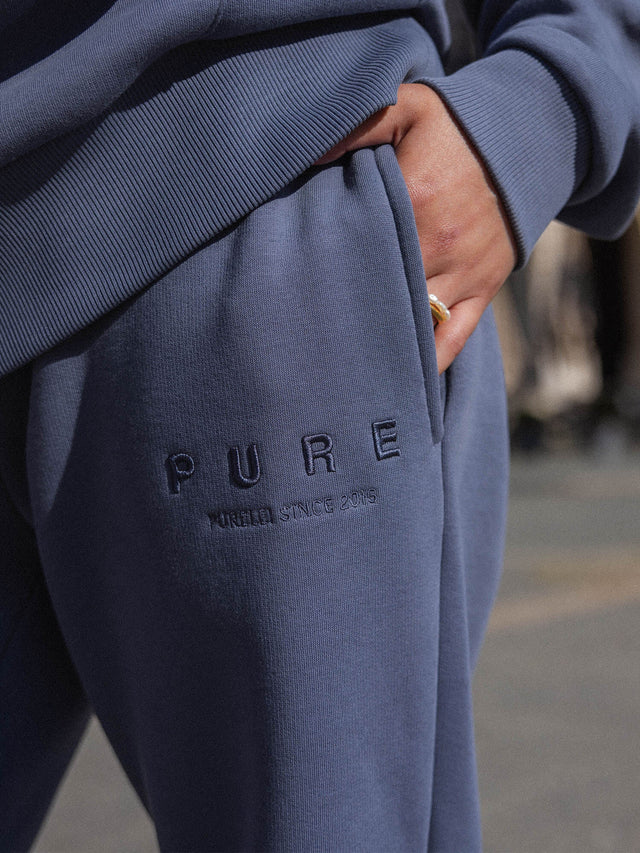 Feeling Pure Sweatpants Dark Blue aus Baumwolle mit geradem Bein und gesticktem PURELEI-Logo in urbaner Atmosphäre
