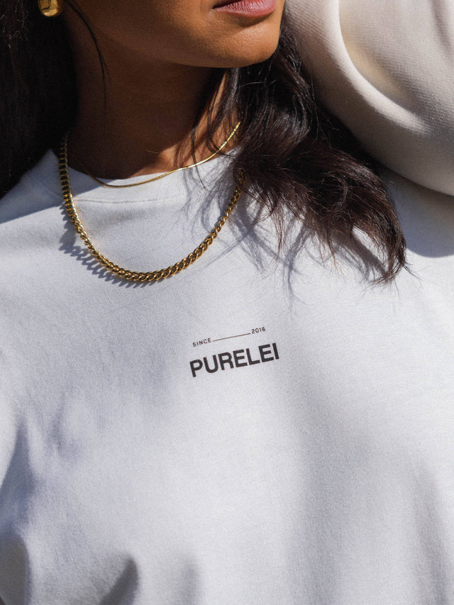 T-Shirt Feeling Pure White in Creme mit PURELEI Schriftzug, oversized Passform, natürliche Eleganz und Alltagstauglichkeit.