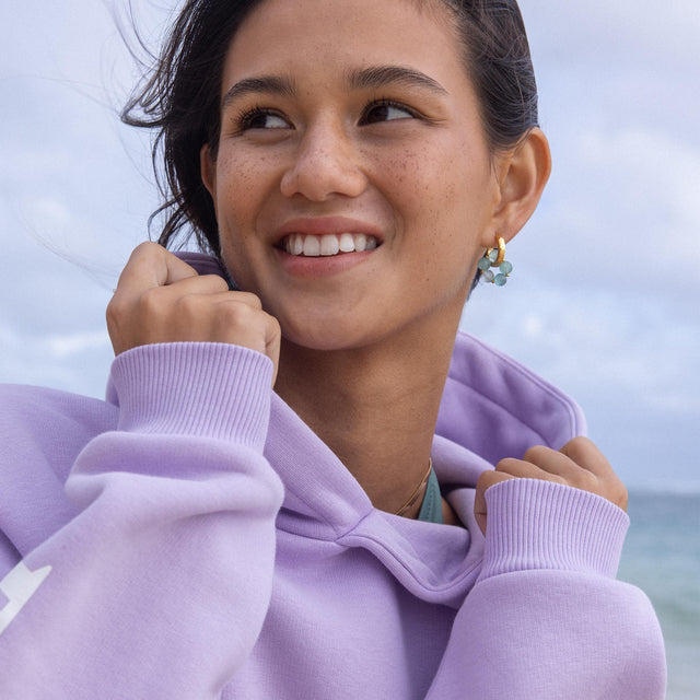 Locker sitzender Pure Hoodie in pastelllila mit Wellenmotiv, cottonmix für sanften Tragekomfort am Strand.
