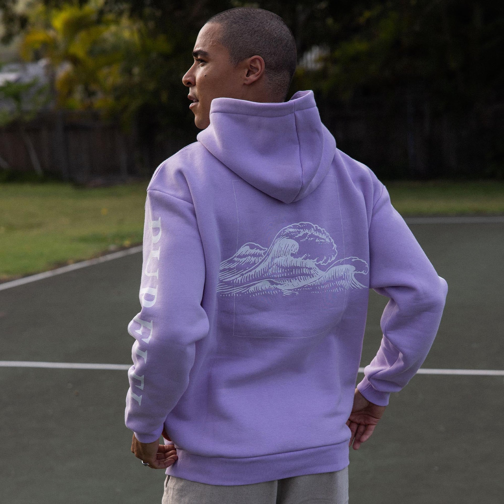 Lila Pure Hoodie aus Baumwollmix, Wellenmotiv auf dem Rücken, PURELEI Schriftzug am Ärmel, locker sitzend.