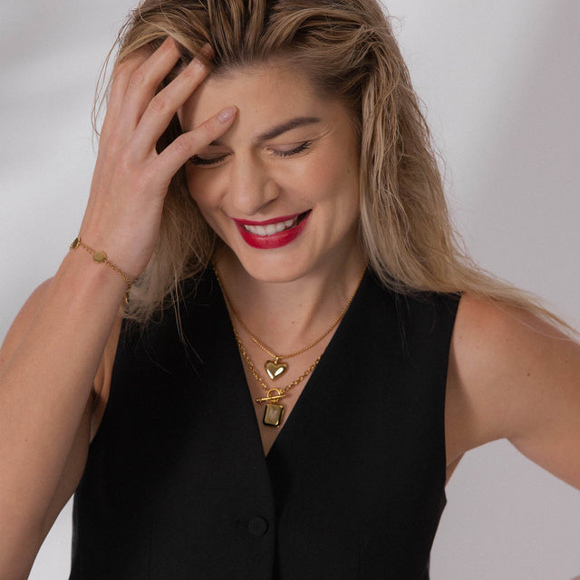 Roségoldene Kette mit Herz- und Anhänger-Design, getragen von einer lächelnden Frau, PURELEI.