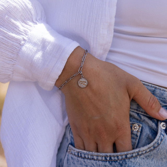 Silbernes Armband mit Anhänger, getragen am Handgelenk, von PURELEI.