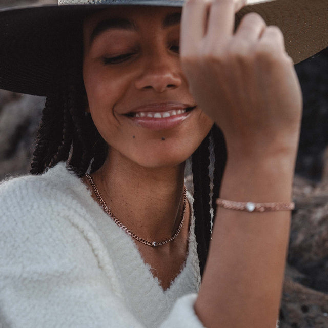 Silberne Kette und Armband mit Muschel-Detail, PURELEI, in warmem Licht getragen.