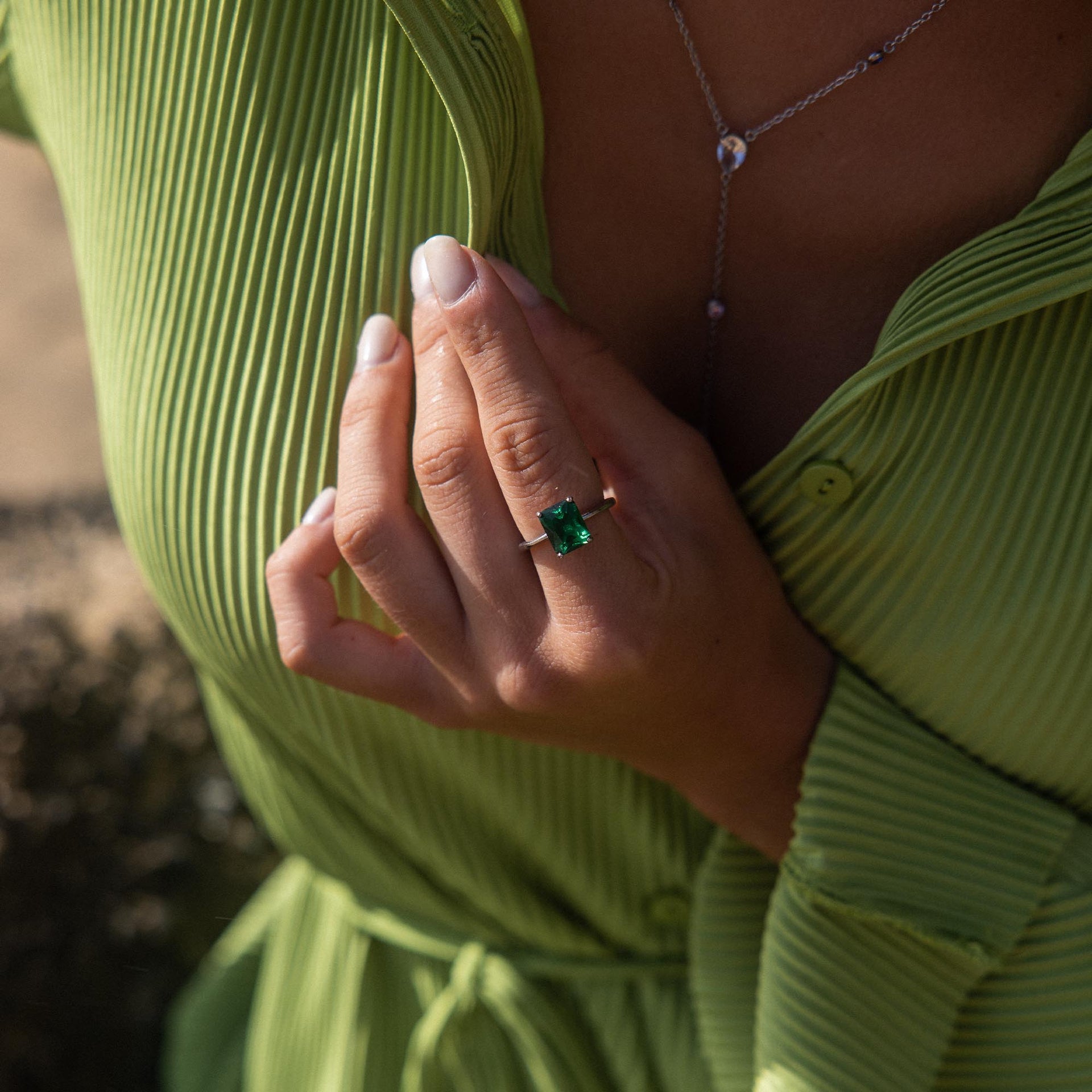 Grüner Ring mit quadratischem Stein, getragen von einer Hand, inspiriert von PURELEI.