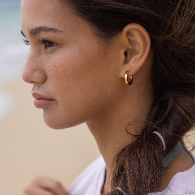 Nickelfreie, goldene Creolen von PURELEI, elegant und zeitlos, strahlen natürliche Schönheit aus.