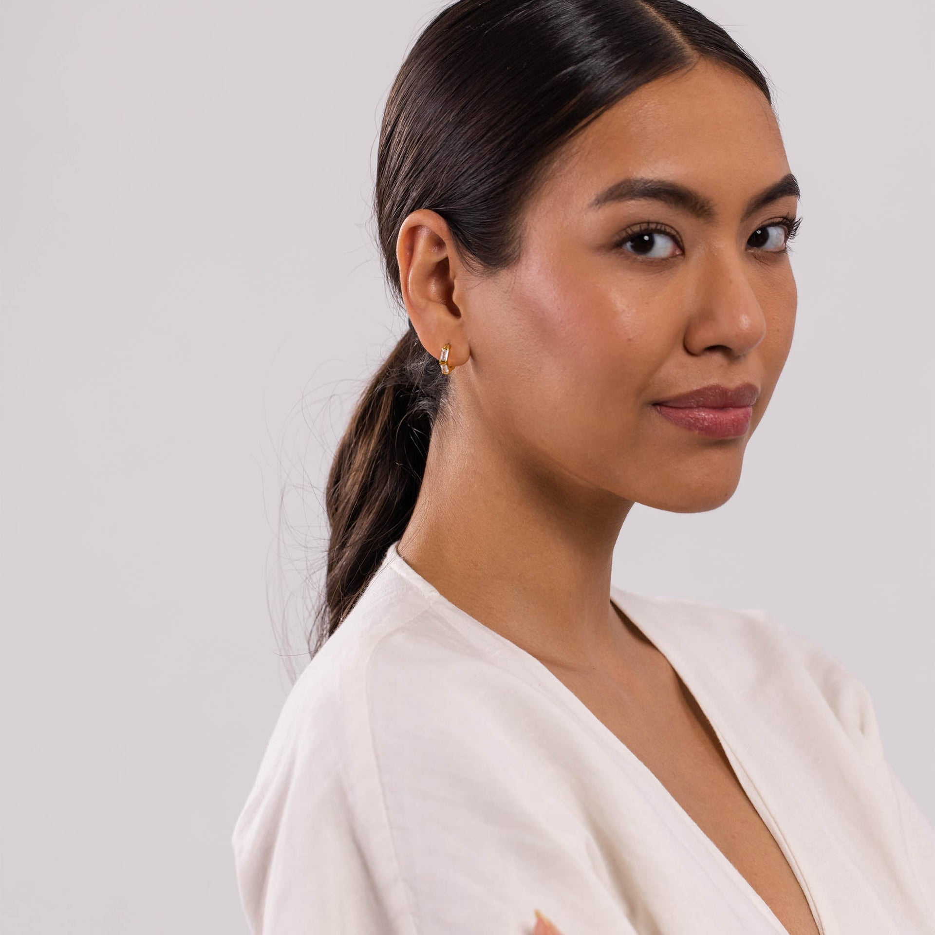 Roségoldene Creolen von PURELEI, elegant und modern, getragen in sanfter Lichtstimmung.