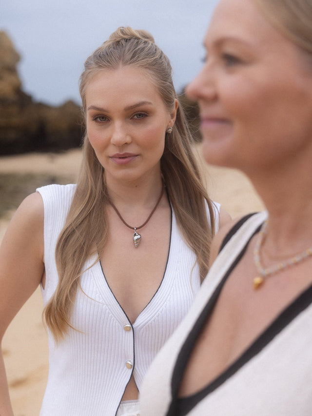 PURELEI Nautical Small Ohrringe in Silber mit Muschelspirale, getragen am Strand, elegant und maritim.