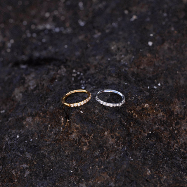 Glow Piercing in Gold und Silber mit funkelnden Zirkonia auf dunklem Lavagestein, PURELEI Nickelfrei.