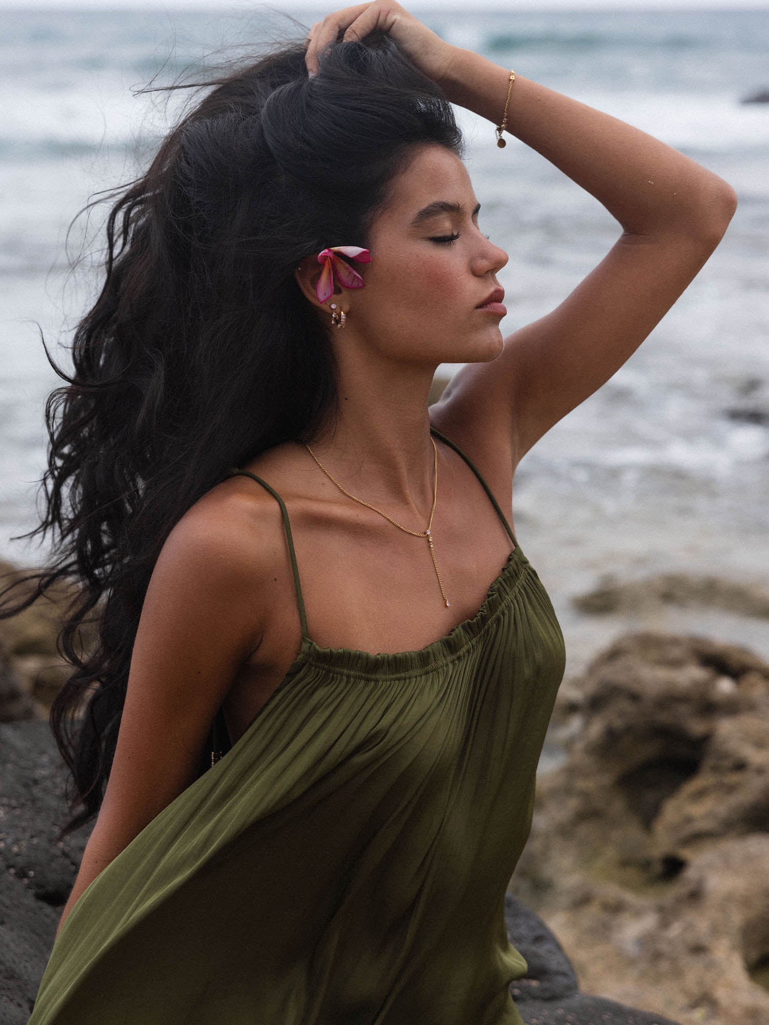 Elegante PURELEI Kette mit zartem Anhänger, getragen am Strand, umgeben von Meeresbrise.