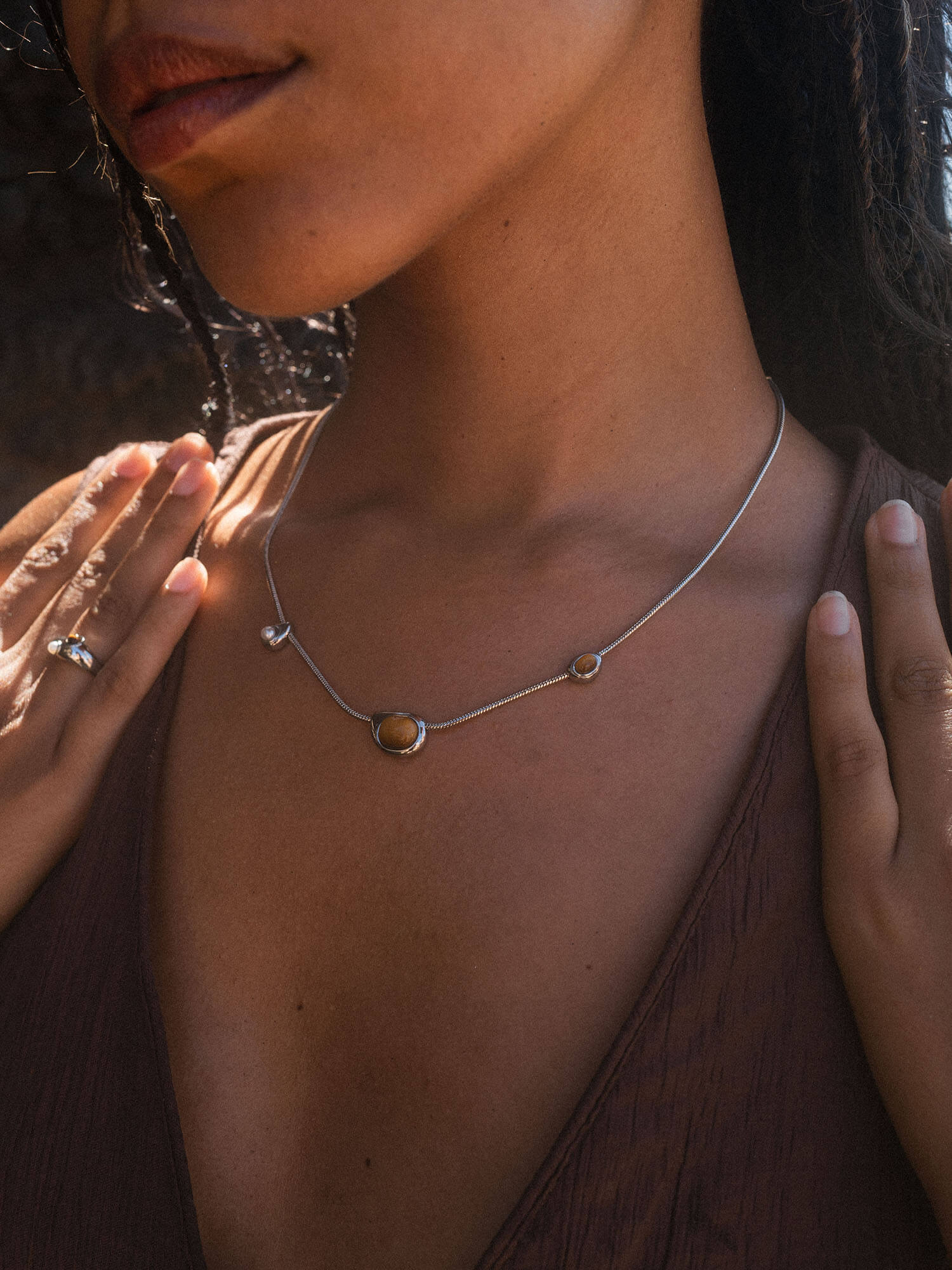 Zarte goldene Kette mit runden Anhängern, getragen in warmem Licht – PURELEI.