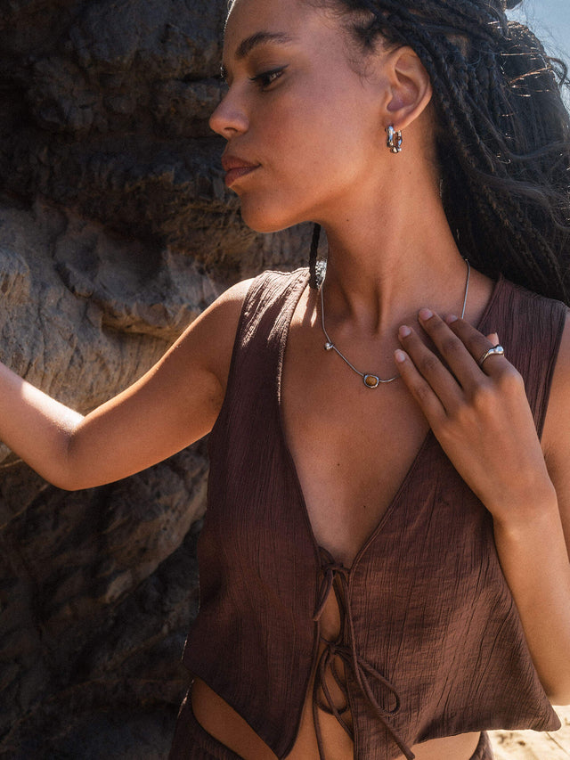 Silberne Creolen und zarte Kette von PURELEI, getragen in warmem Licht, natürliche Eleganz.