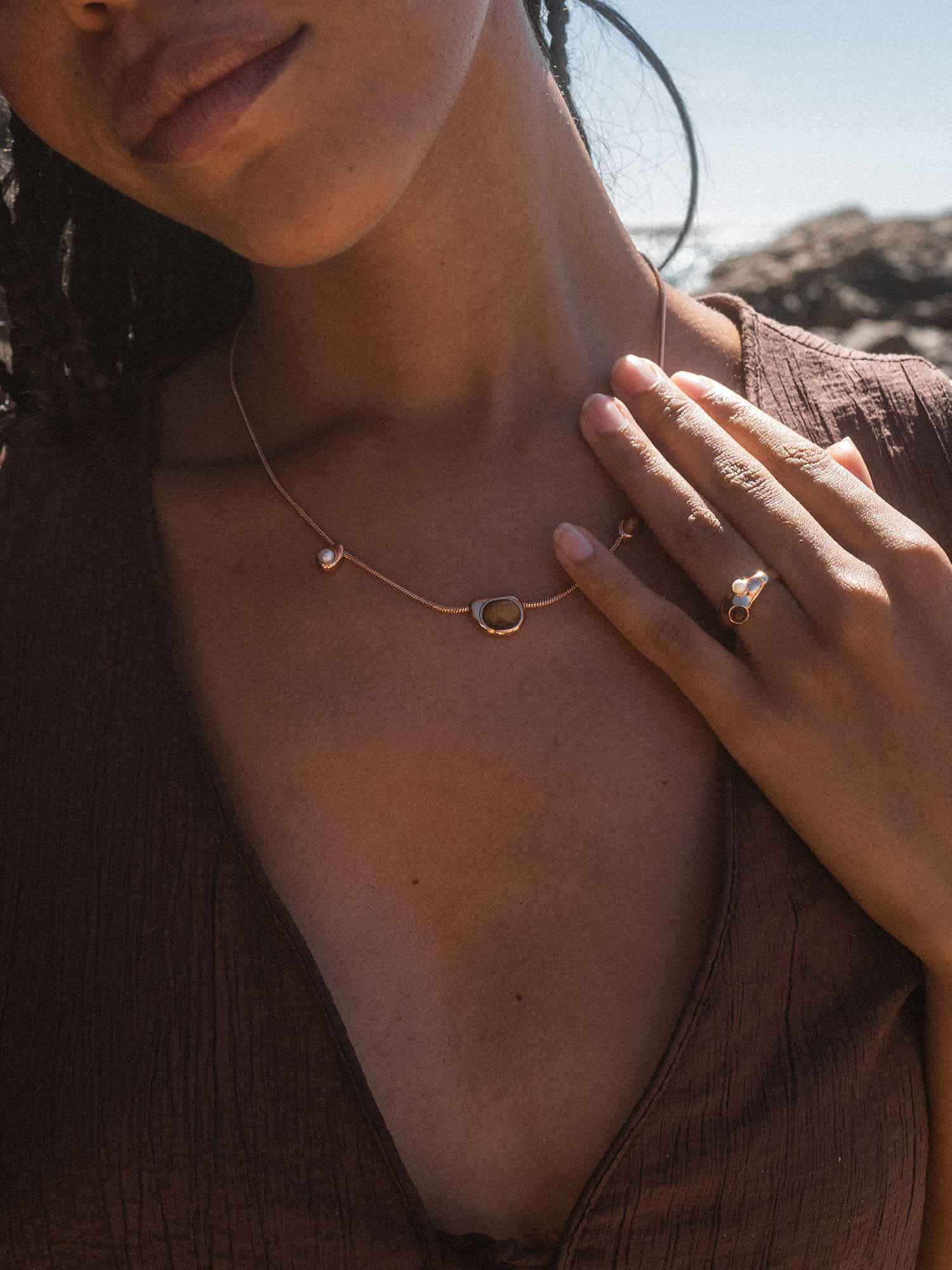 Goldene PURELEI Kette mit einzigartigem Design, getragen in warmem Licht.