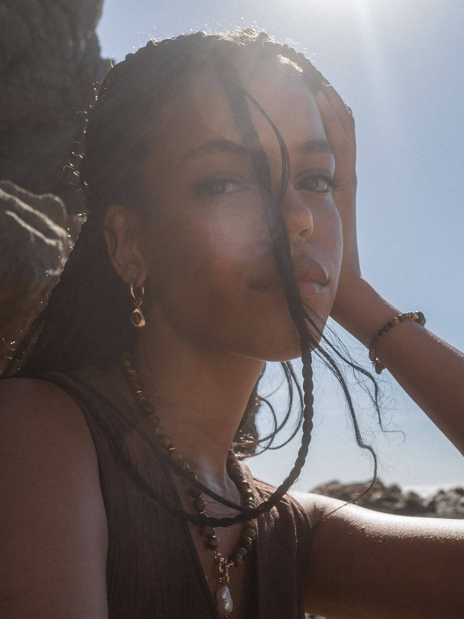 Braunes, natürliches Schmuckset von PURELEI, getragen in sonniger Küstenatmosphäre.