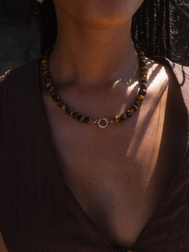 Braune Perlenkette mit goldener Verschlussdetails von PURELEI, elegant und natürlich.