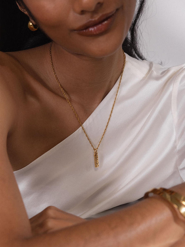 PURELEI Aries Letter Charm, goldene Edelstahlkette mit zartem Sternzeichen-Anhänger, elegant und feminin getragen.