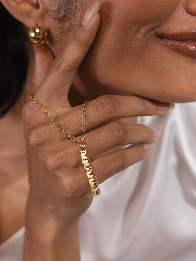 PURELEI Aquarius Letter Charm in 18K Gold, zartes Design, elegant getragen, feminine Leichtigkeit und klare Linien.