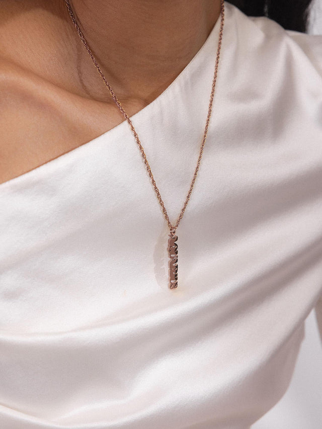 PURELEI Aquarius Letter Charm aus 18K Roségold, minimalistisches Design, elegant und feminin am Hals getragen.