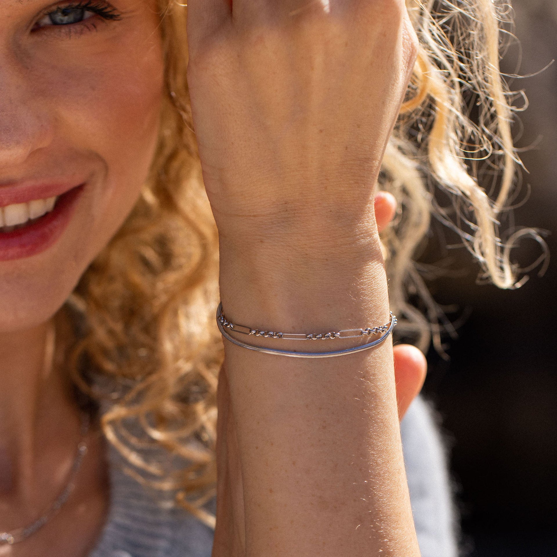 Silbernes Armband mit feinen Details, getragen von einer lächelnden Frau, PURELEI.