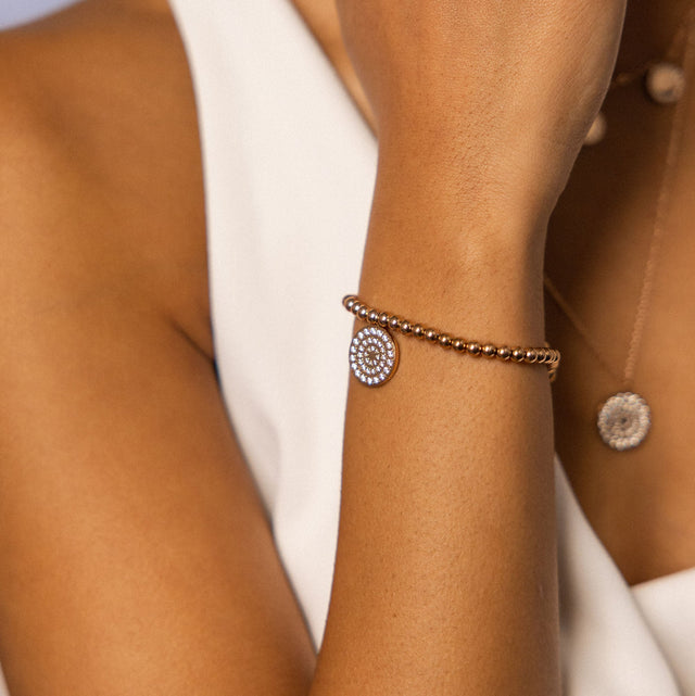 Roségoldenes Armband mit funkelndem Anhänger, getragen am Handgelenk, von PURELEI.
