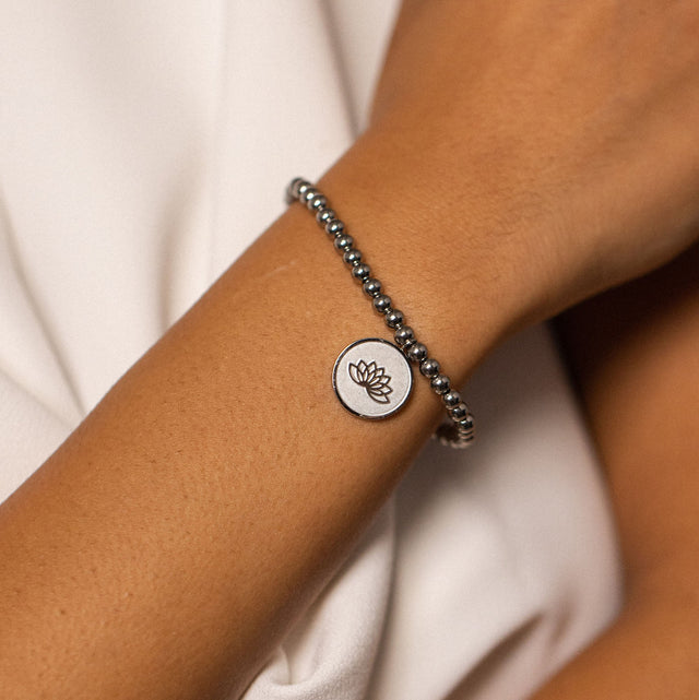 Silbernes Armband mit Lotus-Anhänger, getragen auf zarter Haut, PURELEI.