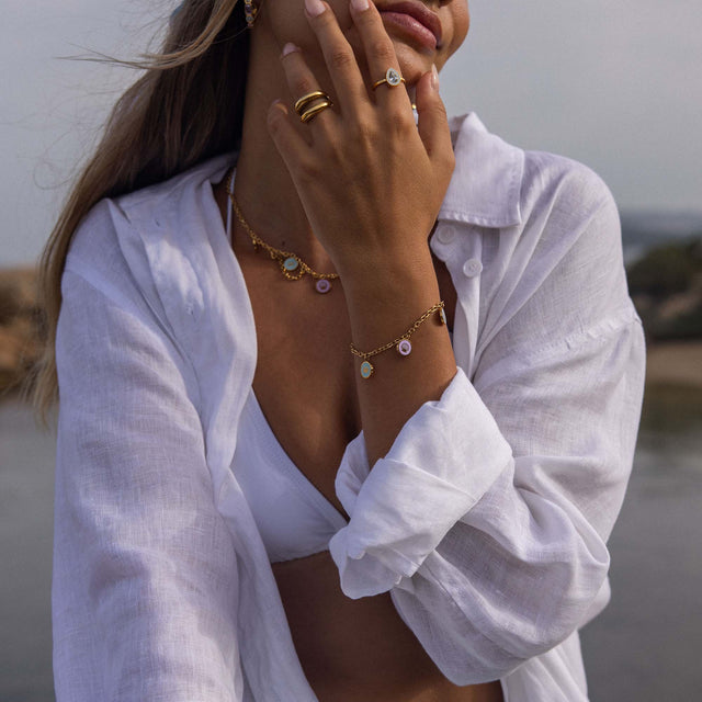 Roségoldene Kette und Ringe mit Muschel-Details, getragen in tropischer Atmosphäre – PURELEI.