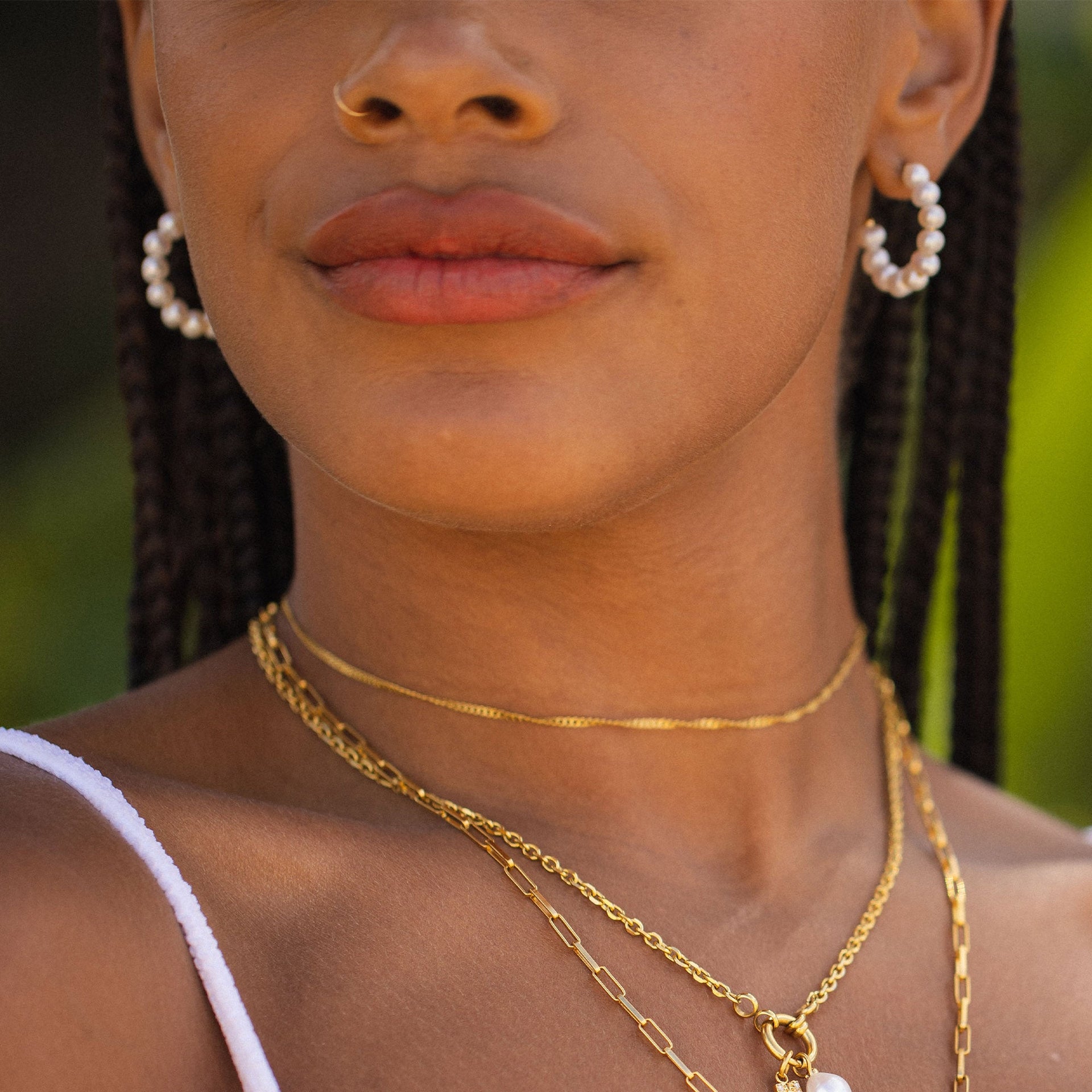 PURELEI Aina Ohrringe aus vergoldetem Edelstahl mit Perlenbesatz, elegant und feminin getragen im Sonnenlicht