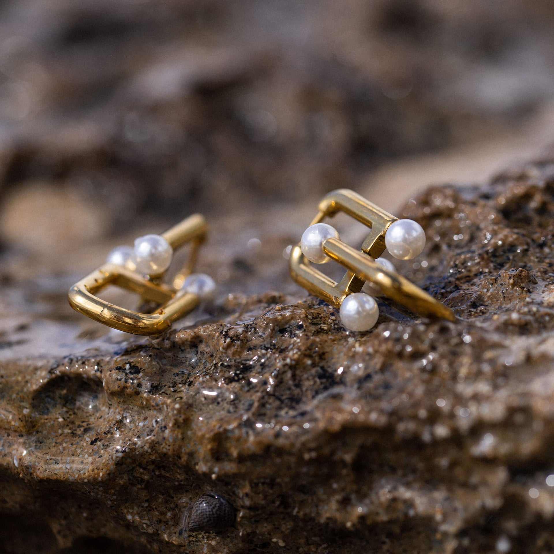 Glace Ohrringe von PURELEI, goldene Edelstahlcreolen mit Muschelperlen, elegant auf natürlichem Stein – feminine Leichtigkeit.