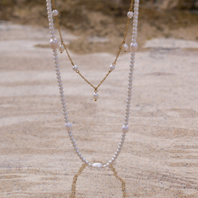 Pearl Drop Perlenkette von PURELEI, zarte Süßwasser- und Muschelperlen in warmem Sandlicht, elegant und feminin.