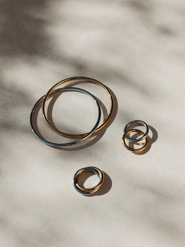 Silberne Ringe und Armreifen von PURELEI auf sanftem Untergrund, elegant und minimalistisch.