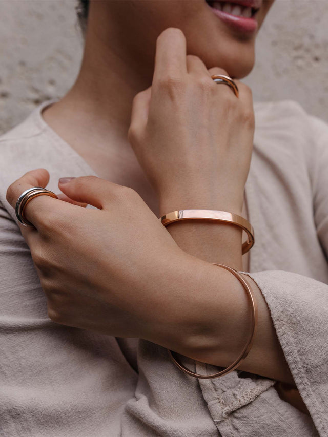 Elegante, roségoldene Armbänder und Ringe von PURELEI, getragen mit lässigem Outfit.