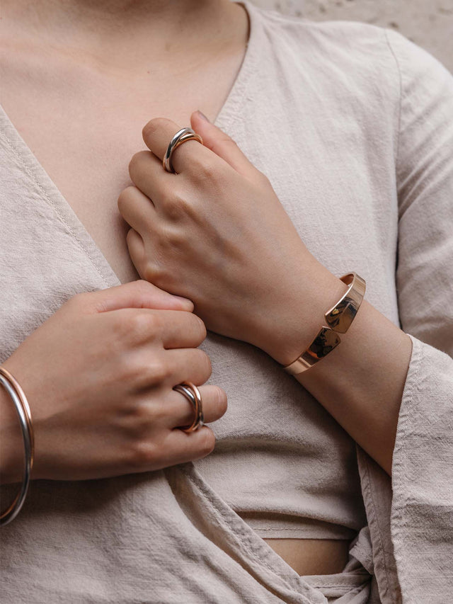 Roségoldenes Armband und Ringe, elegant und modern, getragen auf zartem Leinen, PURELEI.