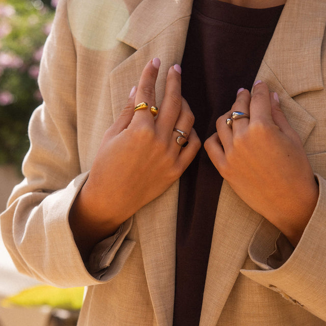 Goldene Ringe von PURELEI, elegant und modern, getragen an zarten Händen in warmem Licht.