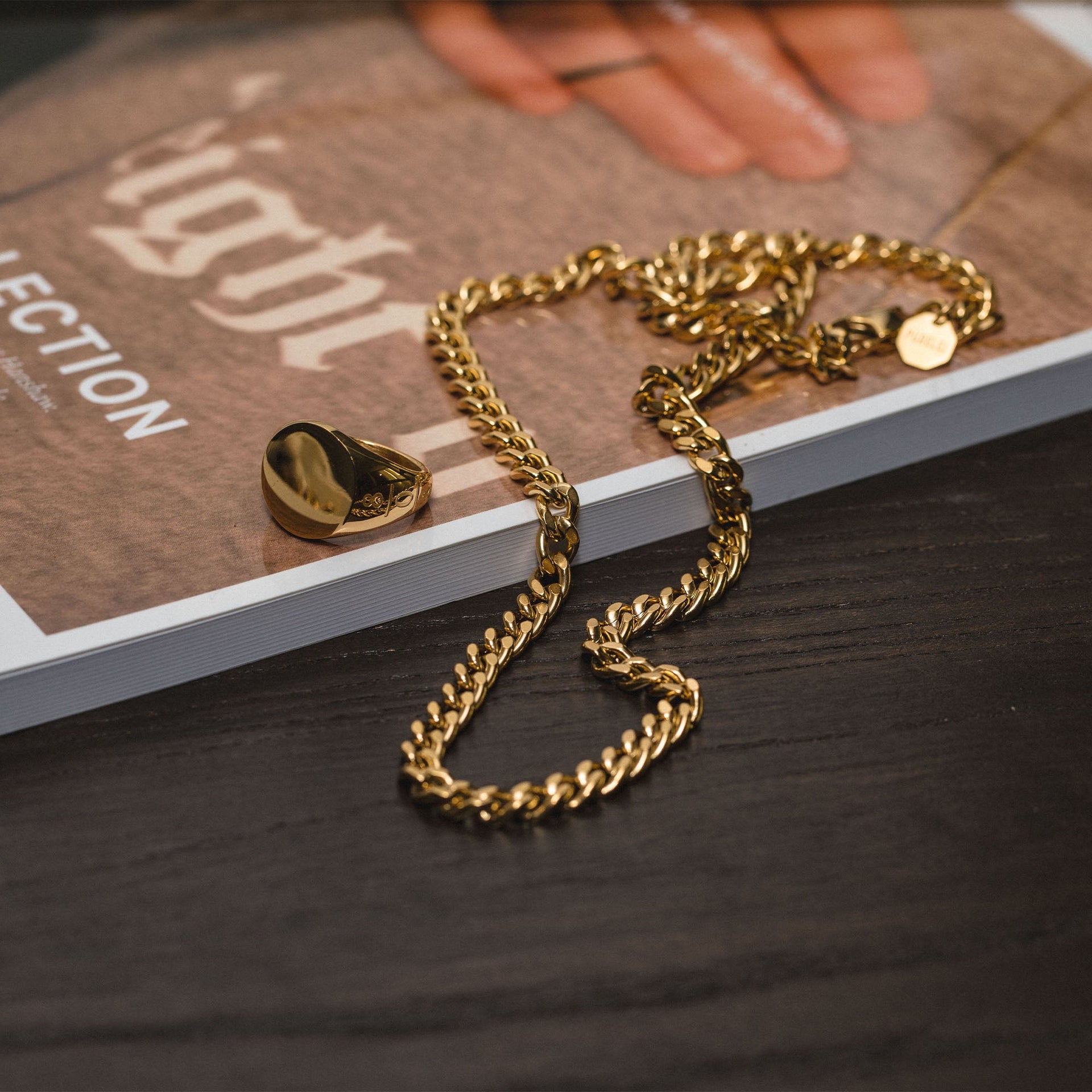 PURELEI Spirit Kette Gold Edelstahl 18K vergoldet, breite Panzerkette auf dunklem Holz, elegant und zeitlos.