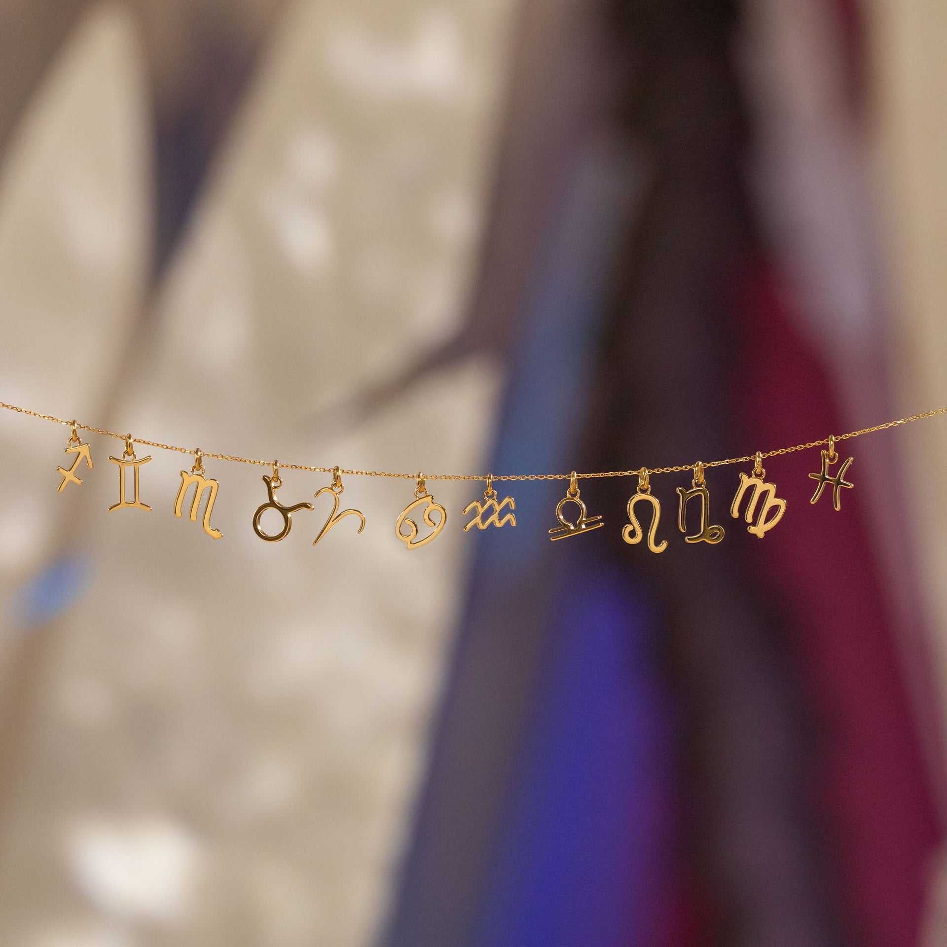 PURELEI Steinbock Zodiac Charm aus 18K Gold gefertigt, fein gearbeitet und elegant inszeniert auf warmer Lichtkulisse