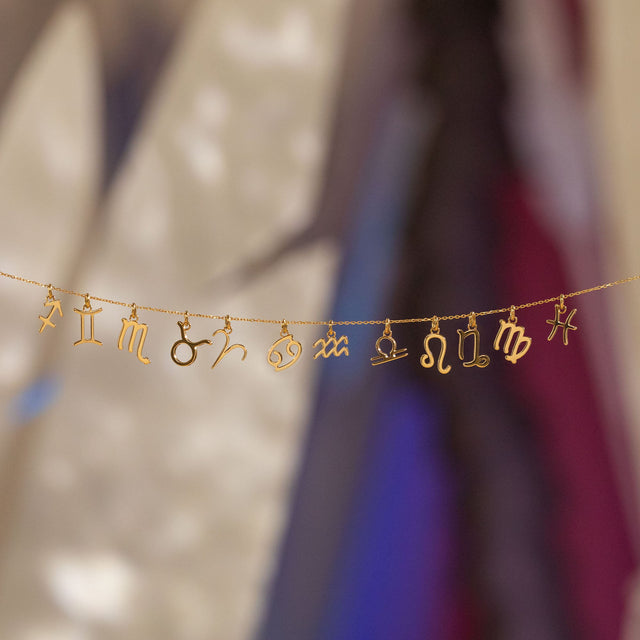 PURELEI Steinbock Zodiac Charm aus 18K Gold gefertigt, fein gearbeitet und elegant inszeniert auf warmer Lichtkulisse