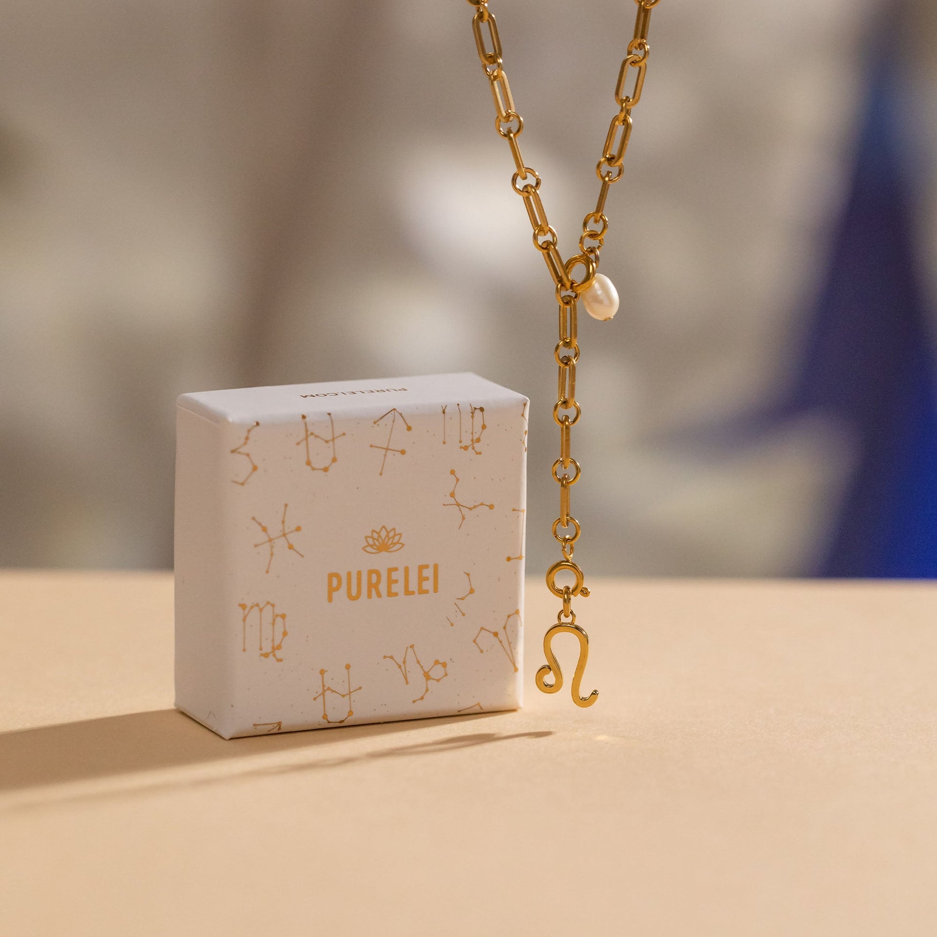 PURELEI Krebs Zodiac Charm in 18K Gold vergoldet mit zarter Perle, elegant vor hellem Hintergrund inszeniert.